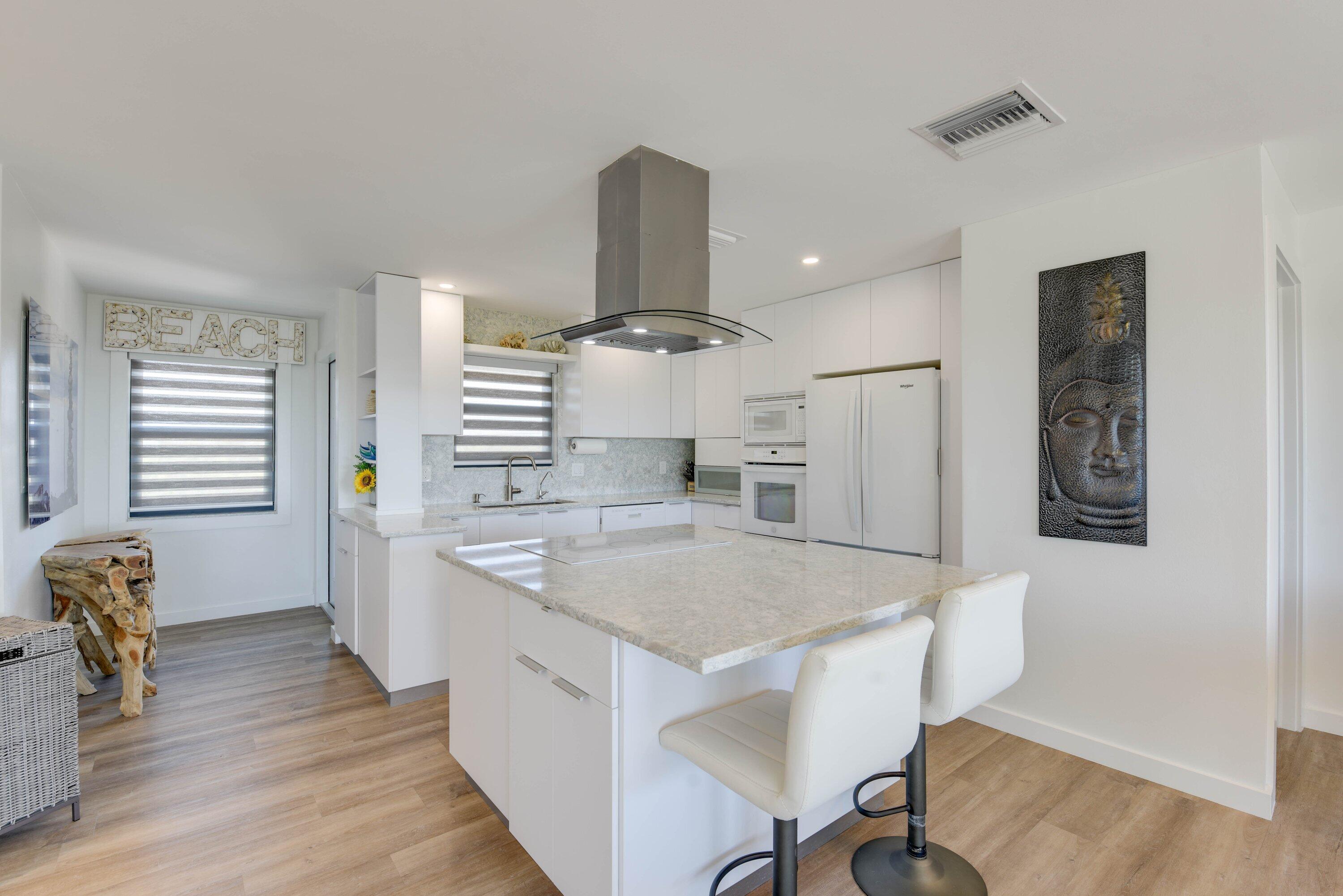 1422 Boca Chica Road Key West, FL 33040 - Photo 24 of 54 a kitchen with stainless steel appliances granite countertop a table chairs and a refrigerator