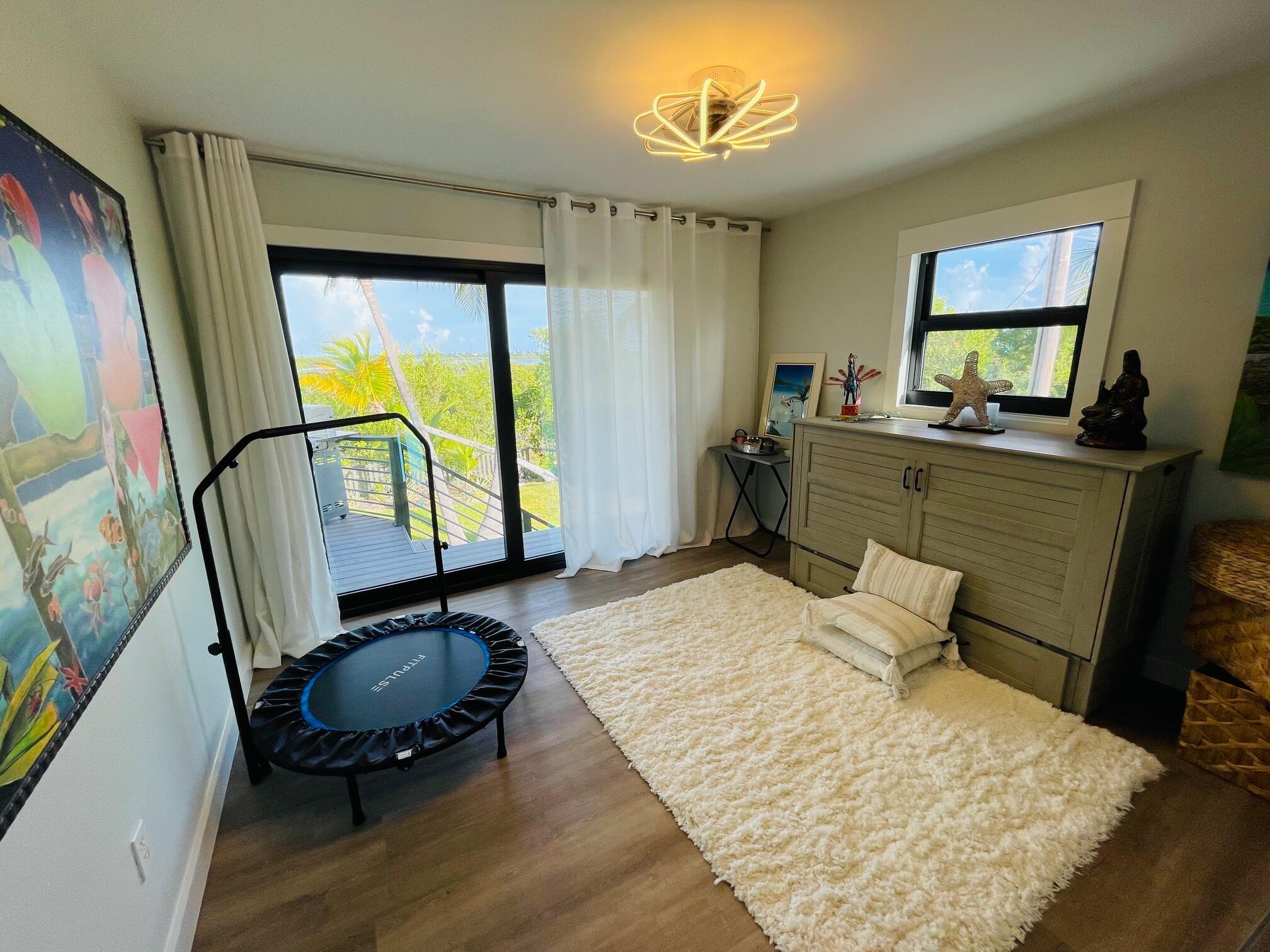 1422 Boca Chica Road Key West, FL 33040 - Photo 33 of 54 a bedroom with a bed a dresser and wooden floor