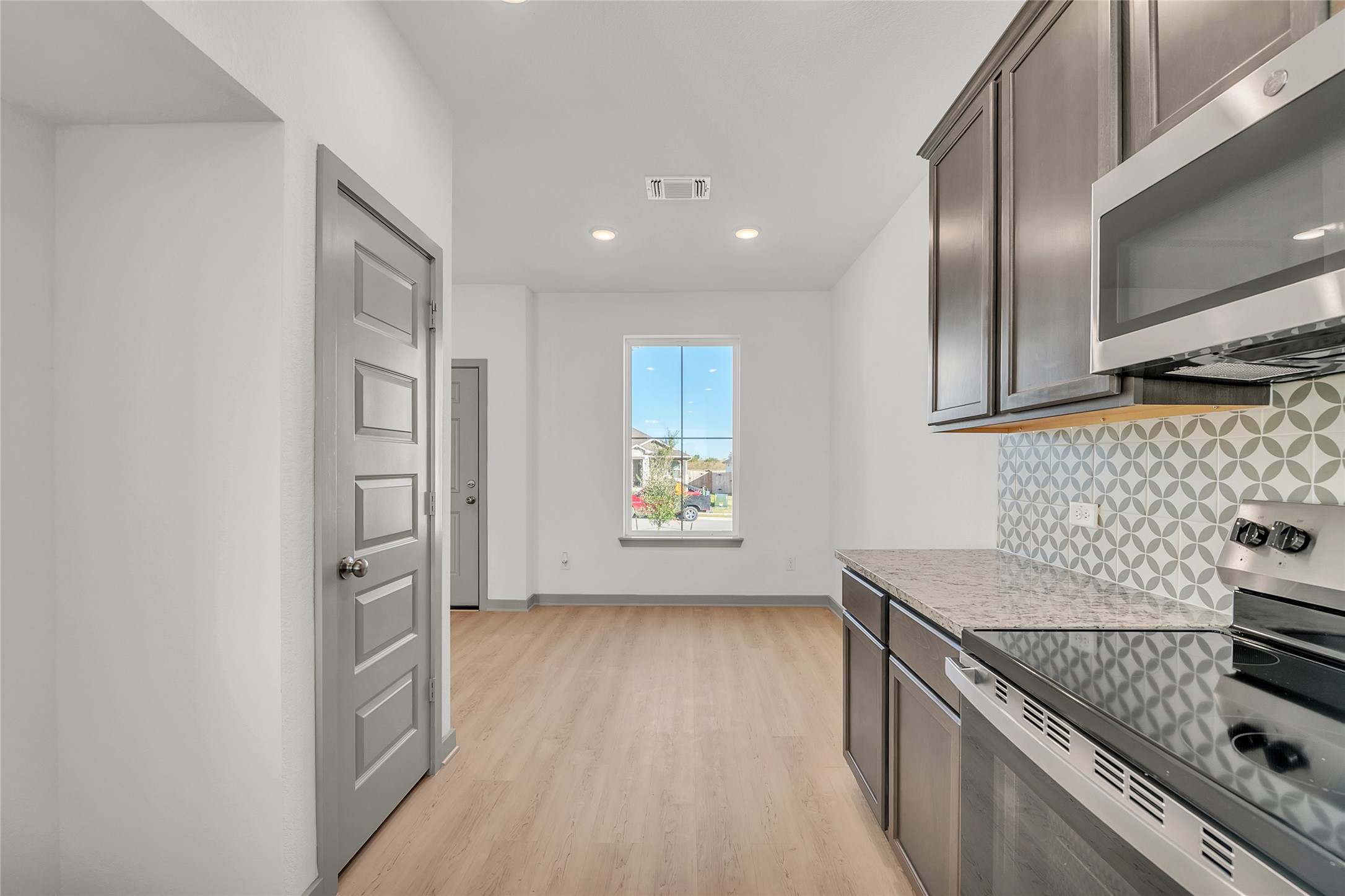 270 Boatright Boulevard Jarrell, TX 76537 - Photo 23 of 30 a kitchen with granite countertop a stove and a refrigerator