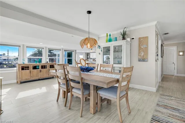 a dining room with furniture a chandelier and wooden floor