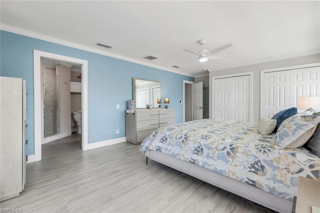 100 Tarpon Road Fort Myers Beach, FL 33931 - Photo 18 of 49 a bedroom with a large bed and a chandelier