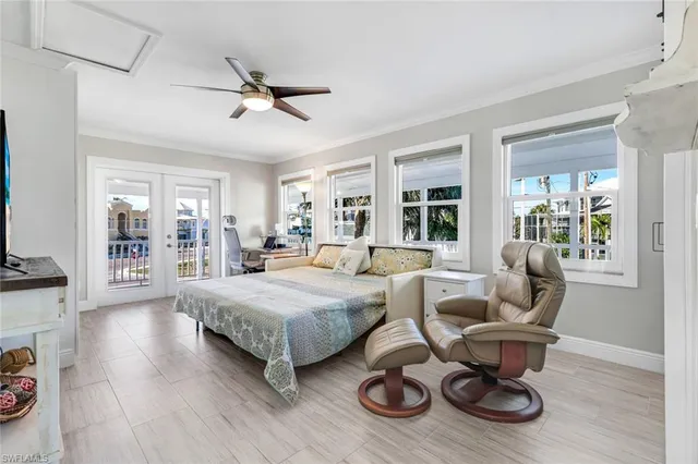 a living room with furniture a rug potted plant and windows