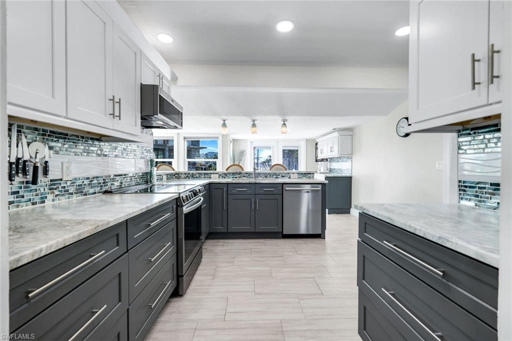 100 Tarpon Road Fort Myers Beach, FL 33931 - Photo 7 of 49 a kitchen with stainless steel appliances granite countertop a sink counter space cabinets and a large window