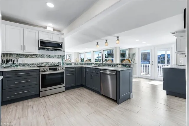 a kitchen with stainless steel appliances kitchen island granite countertop a stove top oven and cabinets