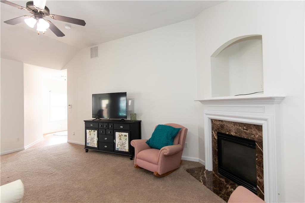 213 Oakleaf Drive Acworth, GA 30102 - Photo 7 of 24 a living room with furniture a fireplace and a flat screen tv