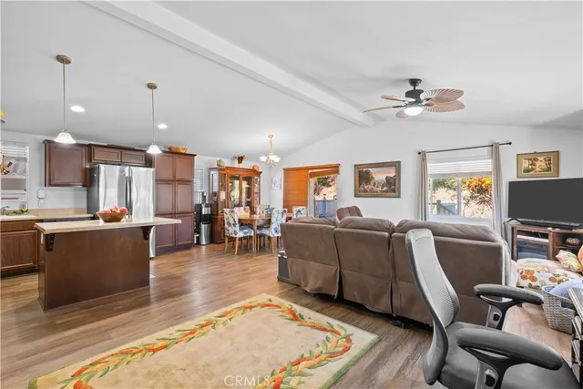 a living room with furniture a flat screen tv and kitchen view