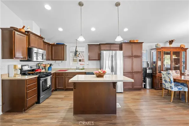 a kitchen with kitchen island a sink counter top space appliances and cabinets
