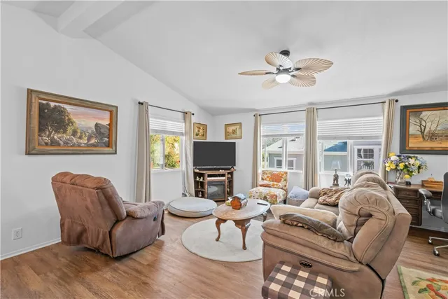 a living room with furniture a flat screen tv and a large window