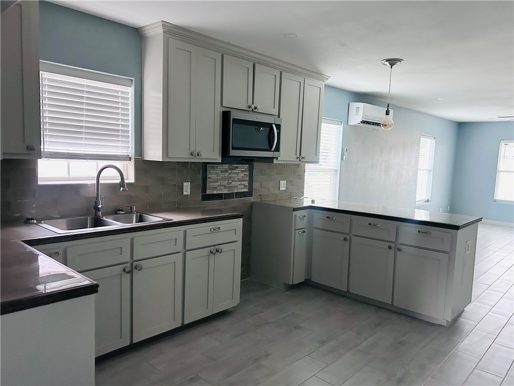 516 East 6th Street, Unit A Alice, TX 78332 - Photo 5 of 16 a kitchen with cabinets appliances a sink and a window