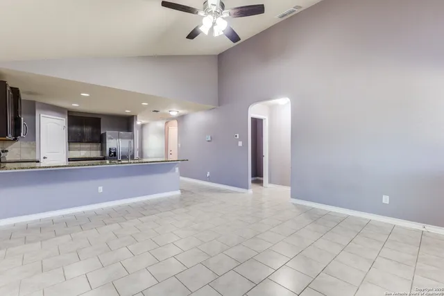 a view of an empty room and kitchen view