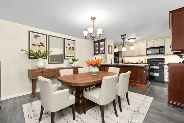 a view of a dining room with furniture a chandelier and wooden floor