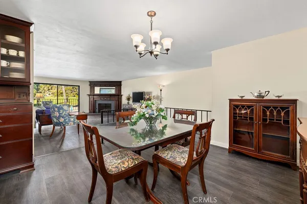 a dining room with furniture a chandelier and wooden floor