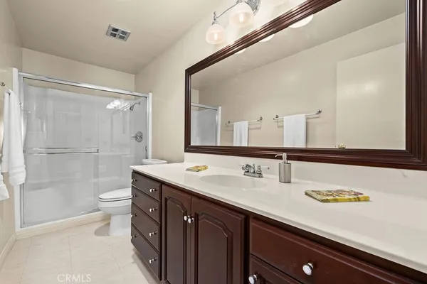 a bathroom with a double vanity sink toilet and a mirror