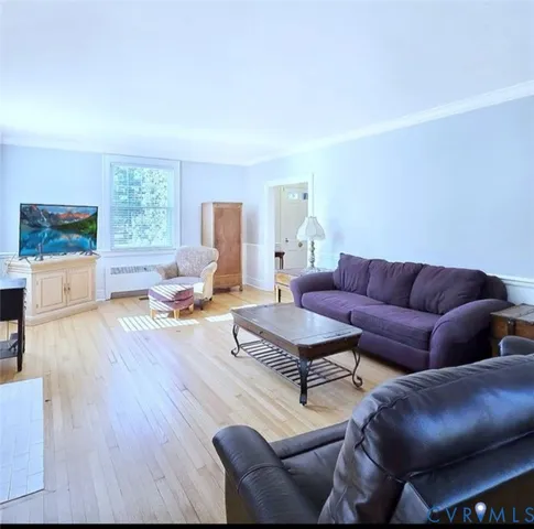 a living room with furniture and a wooden floor