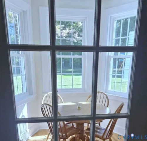 a view of a dining room with furniture large windows and wooden floor