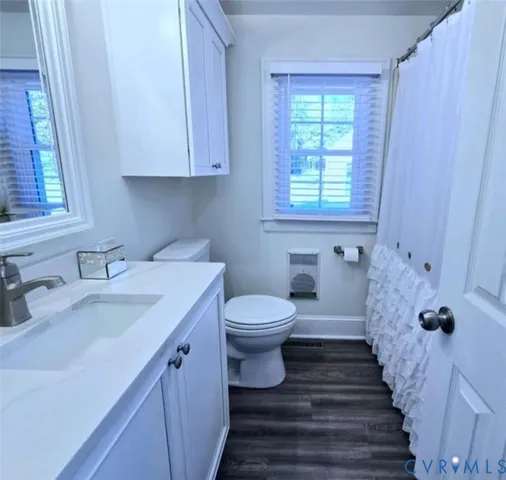 a bathroom with a sink a toilet and a window