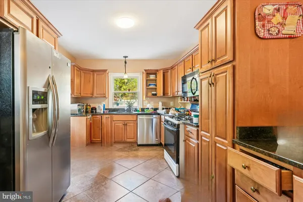 a kitchen with stainless steel appliances granite countertop a refrigerator and a stove top oven