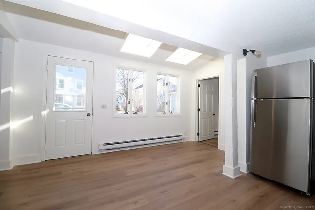 an empty room with wooden floor and a window