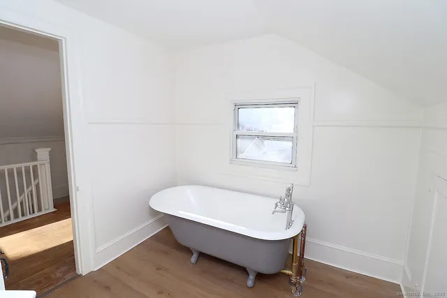 a bathroom with a bathtub and a window