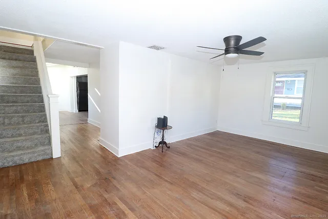 a view of a room with wooden floor and ceiling fan