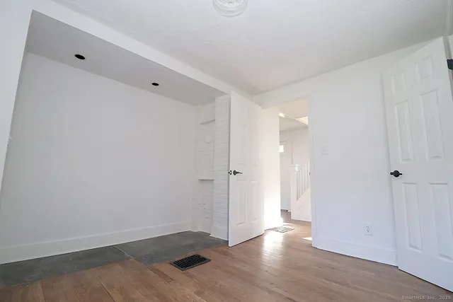 a view of an empty room with wooden floor