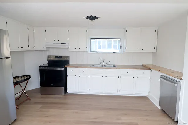 a kitchen with cabinets appliances and a counter space