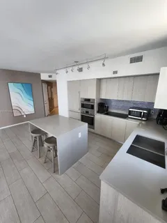 a large bedroom with furniture and a kitchen