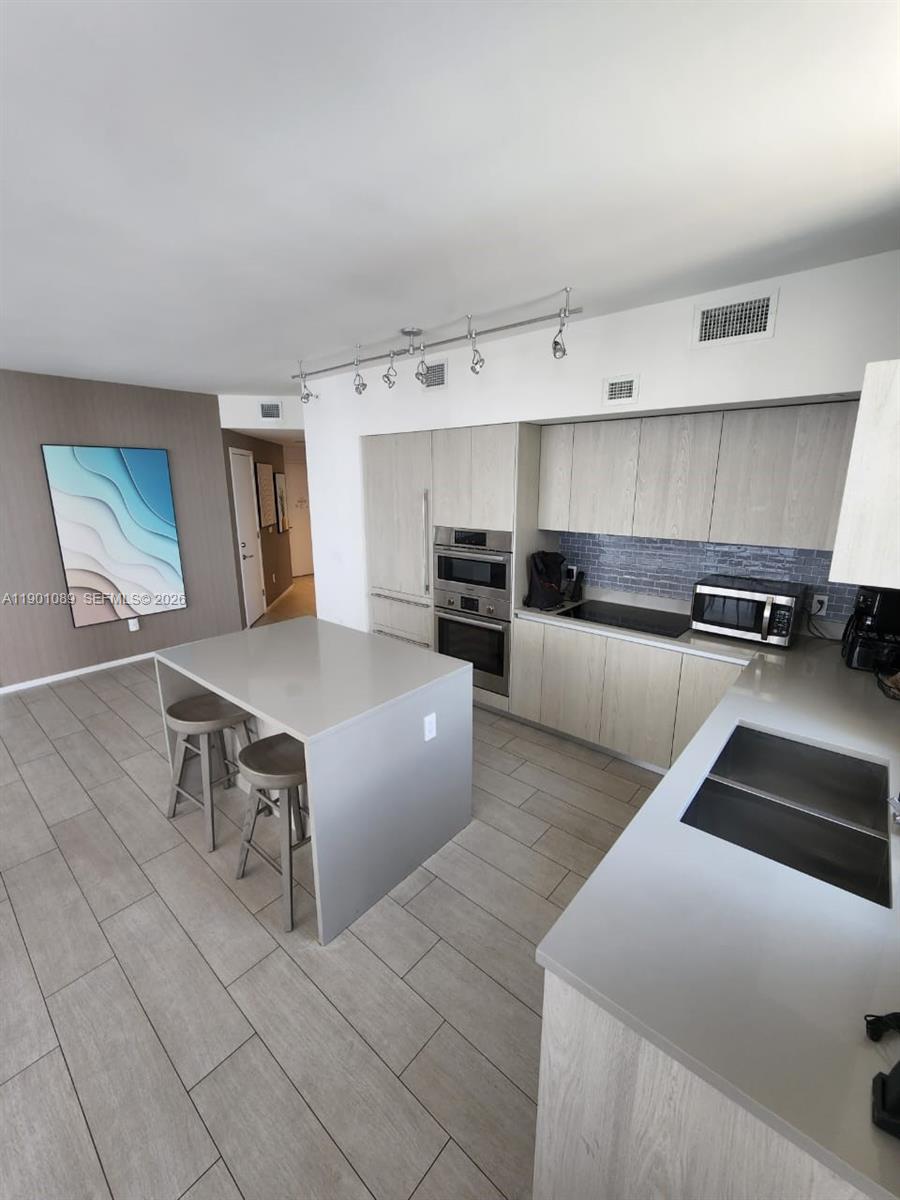 4010 South Ocean Drive, Unit R1709 Hollywood, FL 33019 - Photo 5 of 16 a living room with stainless steel appliances furniture and a kitchen view