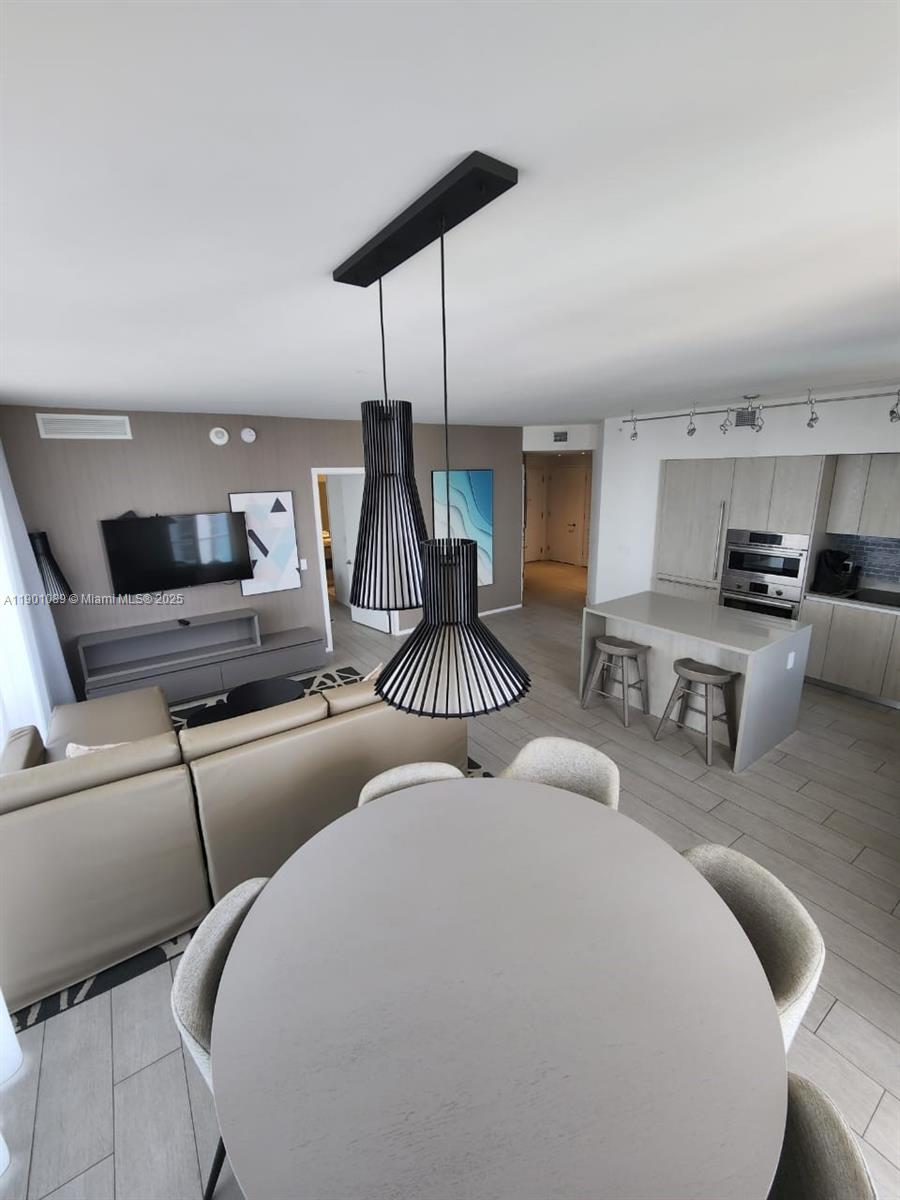 4010 South Ocean Drive, Unit R1709 Hollywood, FL 33019 - Photo 6 of 16 a large bedroom with furniture and a kitchen