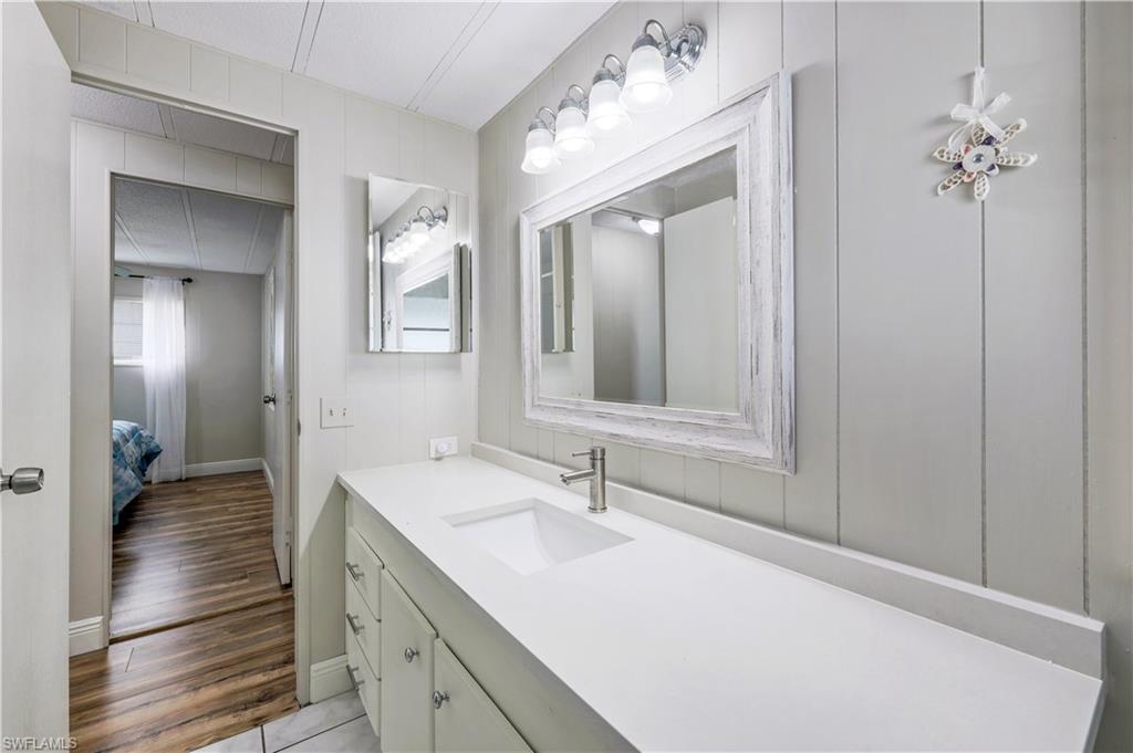 21 Lemans Drive Naples, FL 34112 - Photo 16 of 26 a en suite bathroom with a sink double vanity and a mirror