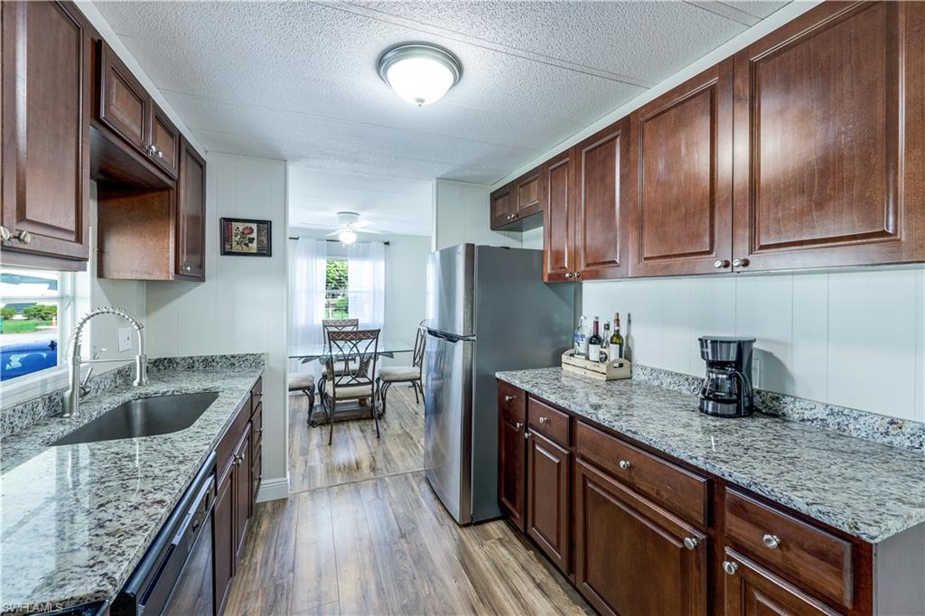 21 Lemans Drive Naples, FL 34112 - Photo 7 of 26 a kitchen with granite countertop lots of counter top space cabinets and stainless steel appliances