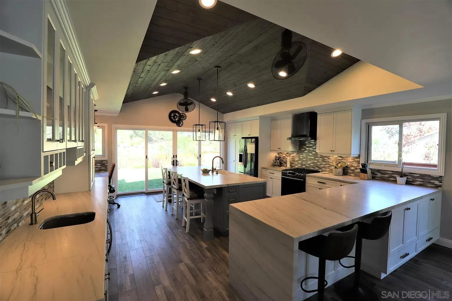 2132 Pleasant Grove Road Encinitas, CA 92024 - Photo 6 of 21 a kitchen with stainless steel appliances granite countertop a sink dishwasher a dining table and chairs with wooden floor
