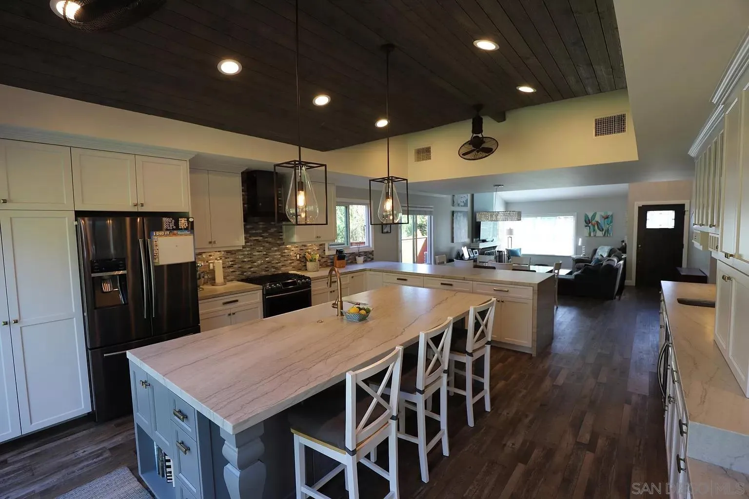 2132 Pleasant Grove Road Encinitas, CA 92024 - Photo 10 of 21 a kitchen with stainless steel appliances kitchen island granite countertop a table chairs and a refrigerator