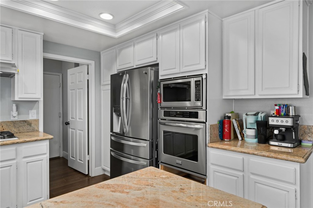 5810 Greens Drive Riverside, CA 92509 - Photo 13 of 31 a kitchen with white cabinets and stainless steel appliances