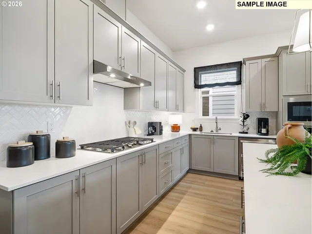 a kitchen with white cabinets and sink