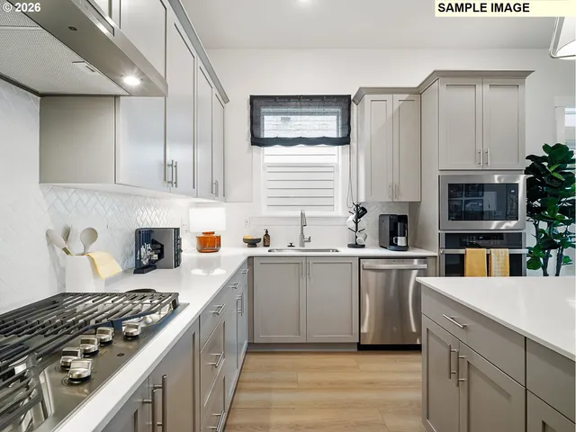 a kitchen with stainless steel appliances a sink stove and cabinets
