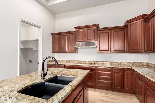 a kitchen with granite countertop a sink stainless steel appliances and cabinets