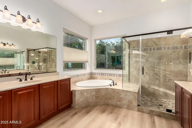 a bathroom with a tub a sink shower and mirror