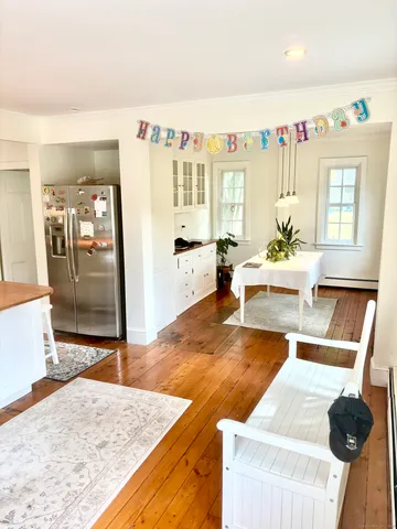 a living room with stainless steel appliances kitchen island granite countertop furniture and a large window