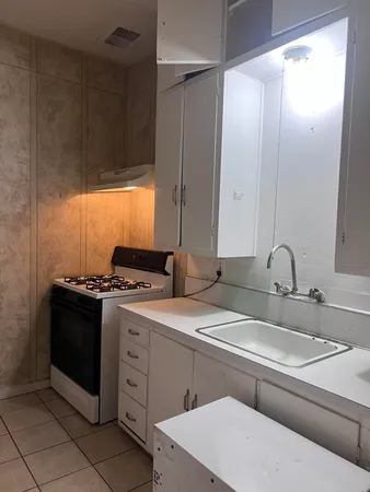 a kitchen with a sink stove and cabinets