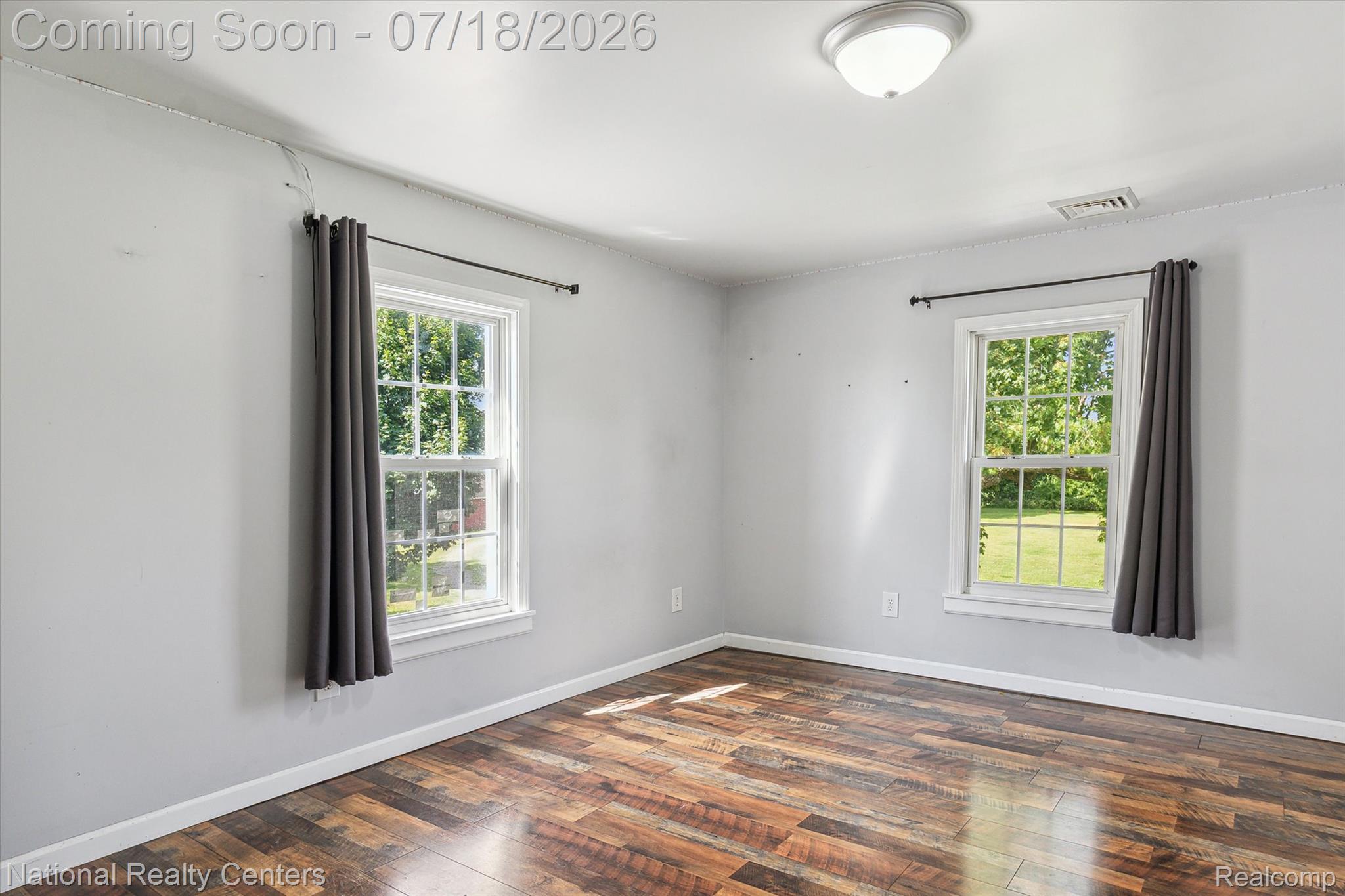 9589 Clinton Macon Road Tecumseh, MI 49286 - Photo 23 of 48 Room featuring wood-finish flooring, two large windows with white trim, and light-toned walls