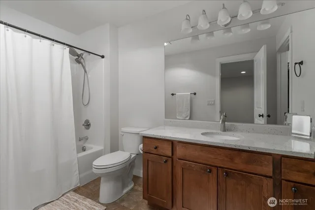 a bathroom with a granite countertop sink toilet and shower