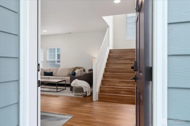 a view of entryway and hall with wooden floor
