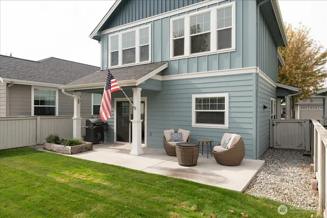 a view of brick house with potted plants and a table and chairs