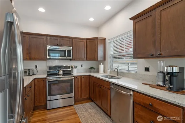 a kitchen with stainless steel appliances granite countertop a sink stove and microwave