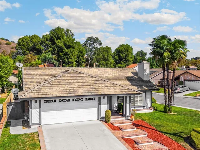a view of a house with garden and a tree