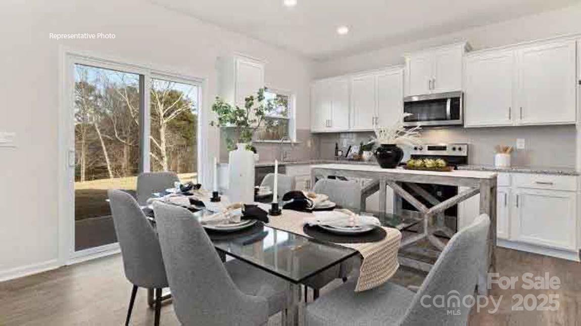 1047 Two Brothers Lane York, SC 29745 - Photo 8 of 18 a kitchen with stainless steel appliances a stove a sink a microwave a dining table and chairs