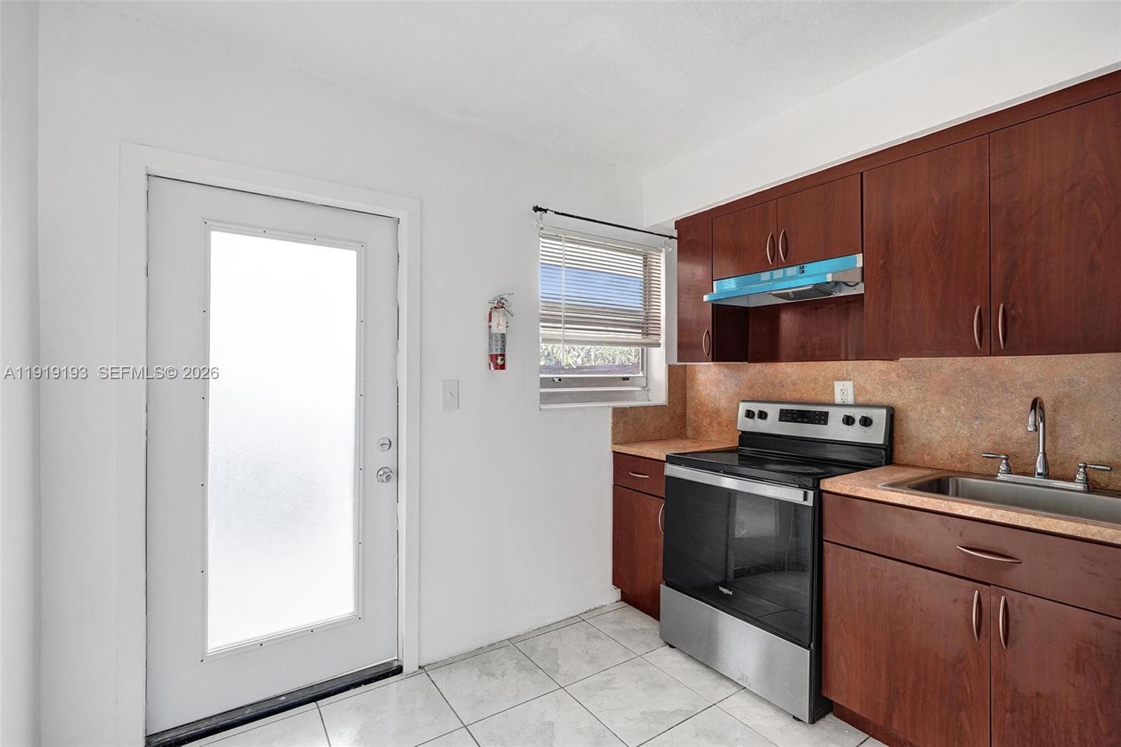 29 Southwest 8th Avenue, Unit 1 Dania Beach, FL 33004 - Photo 4 of 17 a kitchen with stainless steel appliances granite countertop a refrigerator and a stove top oven