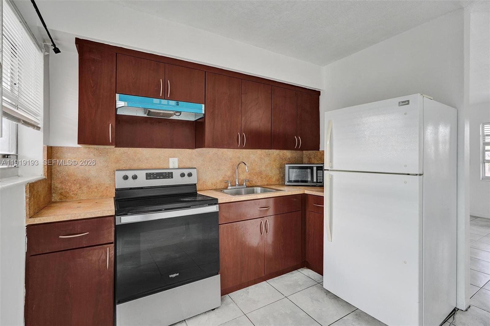 29 Southwest 8th Avenue, Unit 1 Dania Beach, FL 33004 - Photo 5 of 17 a kitchen with stainless steel appliances granite countertop a refrigerator and a stove