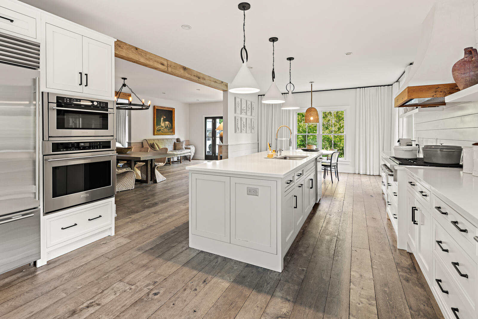 311 Mill Road New Canaan, CT 06840 - Photo 6 of 30 a large white kitchen with stainless steel appliances granite countertop a stove a sink dishwasher and a fireplace with wooden floor